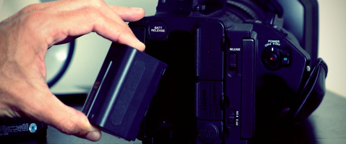 Homem instalando bateria na camera
