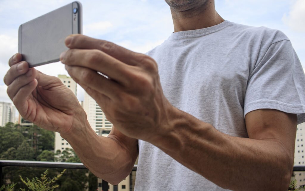 Homem segurando celular na horizontal