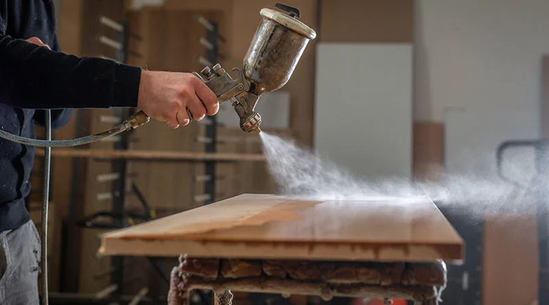 Homem usando equipamento de spray em ateliê