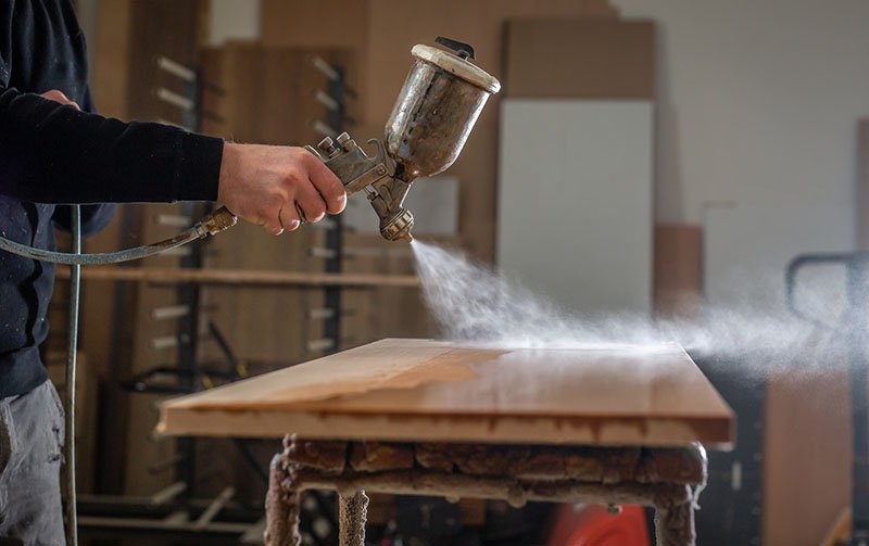 Homem usando equipamento de spray em ateliê