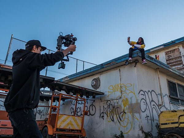 Videomaker filmando com câmera no estabilizador